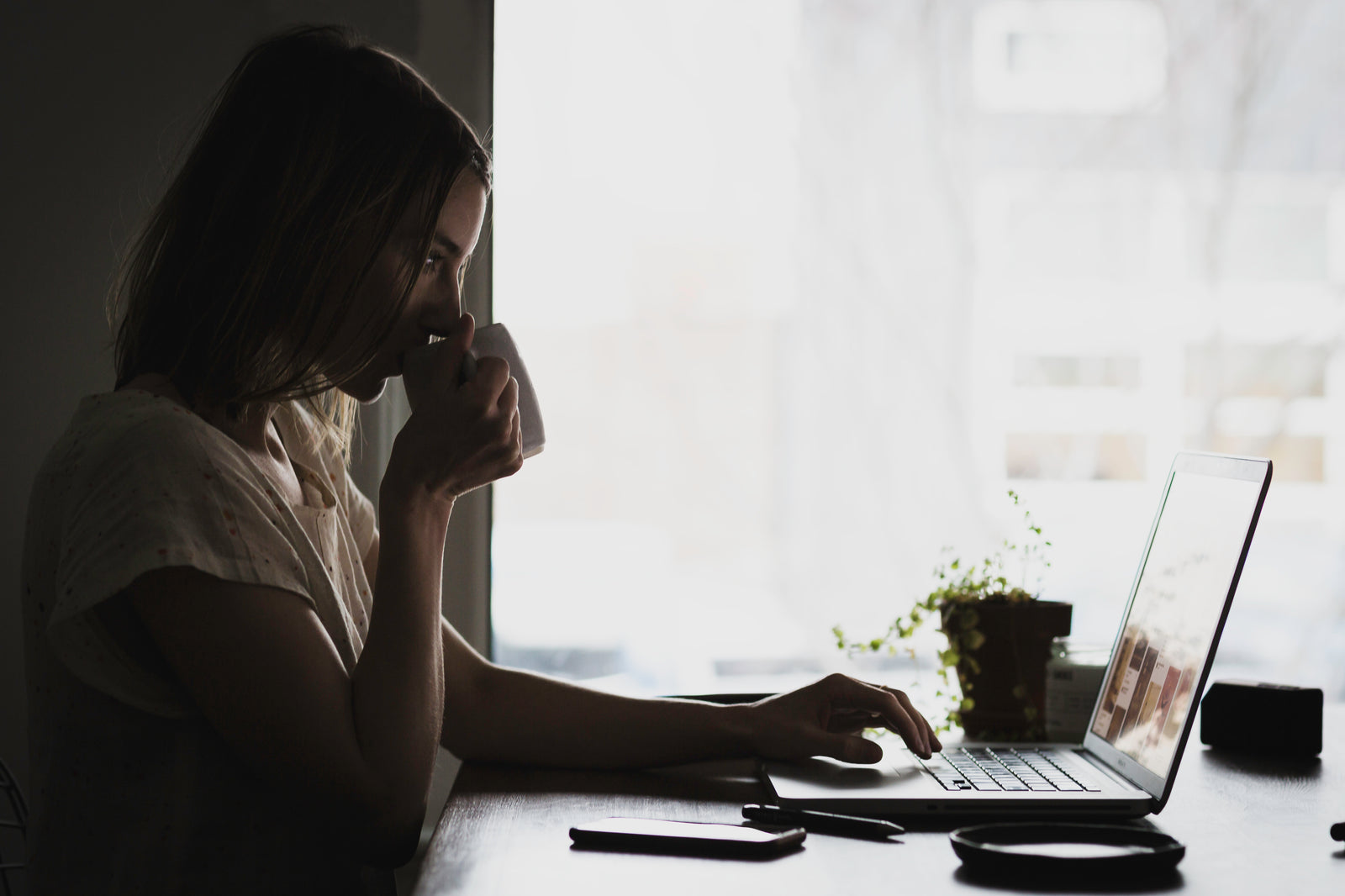 A person learning on a laptop with a morning coffee